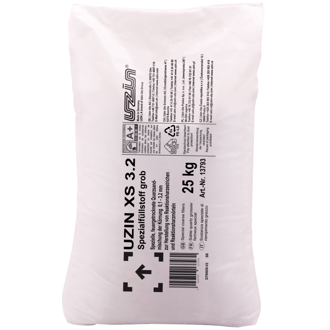 UZIN_Dummy_XS 3.2-25kg_2018-03 Gros plan d'un grand sac d'emballage en plastique blanc pour matériaux de construction, de la marque 'UZIN'. Le sac présente des textes imprimés en noir et des symboles techniques disposés principalement en colonne verticale : le nom et la description du produit (charge grossière spéciale de quartz), le poids '25 kg', un numéro d'article et un code-barres. On distingue des marquages fabricant et de sécurité, notamment une étiquette d'émissions intérieures A+, un symbole de recyclage portant la mention '04 PE-LD', des flèches de manutention et plusieurs adresses de contact d'Uzin dans différents pays. La surface du sac est légèrement froissée et brillante, l'impression est contrastée et lisible ; l'image, prise sur fond blanc, met l'accent sur la zone centrale de l'étiquette et des marquages.